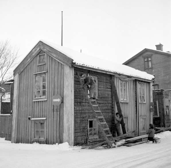 Människor arbetar med fasaden på gammalt trähus. Foto Paul Lindgren