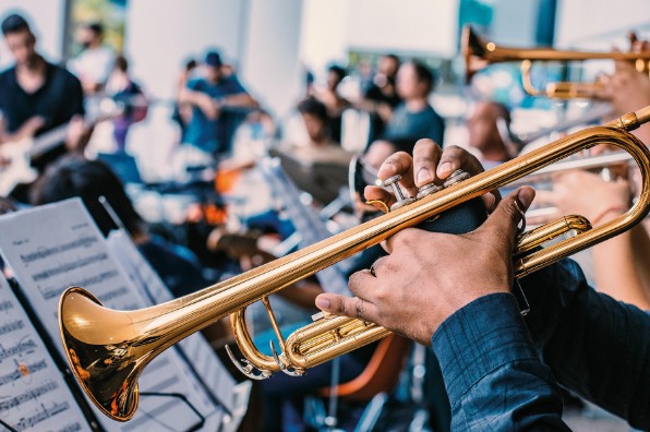 En orkester med en trumpet i fokus. Foto: Unsplash. 